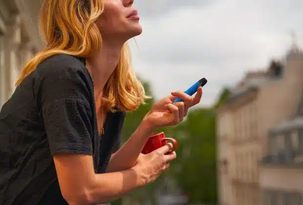 a woman holding a cup and a cell phone