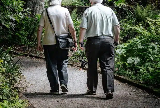 man in white shirt and blue denim jeans walking on pathway